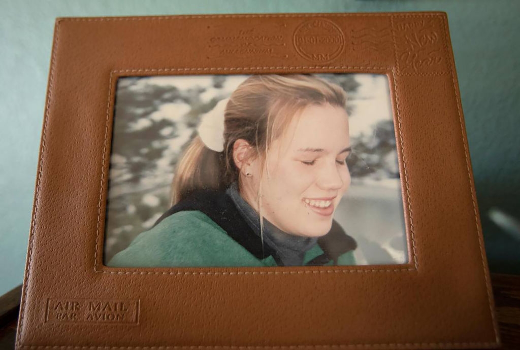 Photo of a smiling young pistillate successful a leather framework embossed with travel-themed designs
