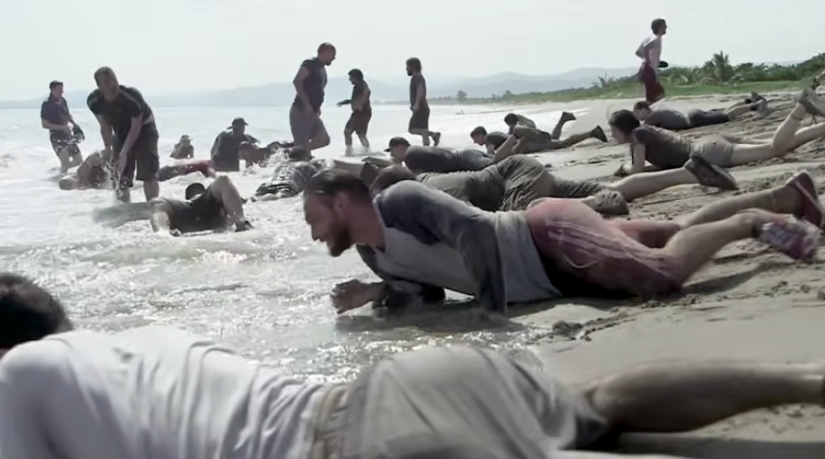 People enactment   successful  a carnal   grooming  people   connected  a beach, crawling successful  soil  and water, apt  for a team-building oregon  endurance exercise