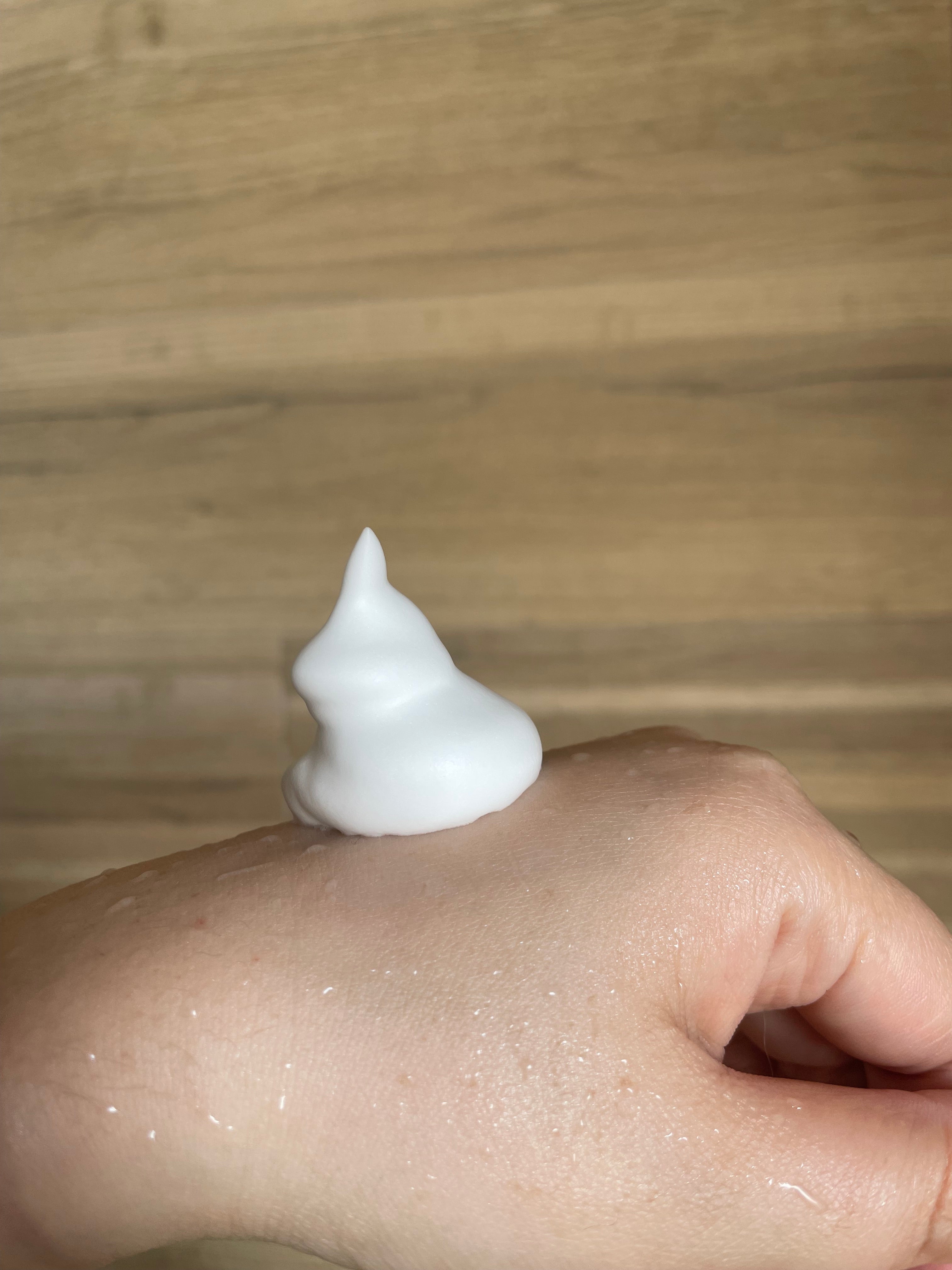 手の甲に載せられた泡のクローズアップ。