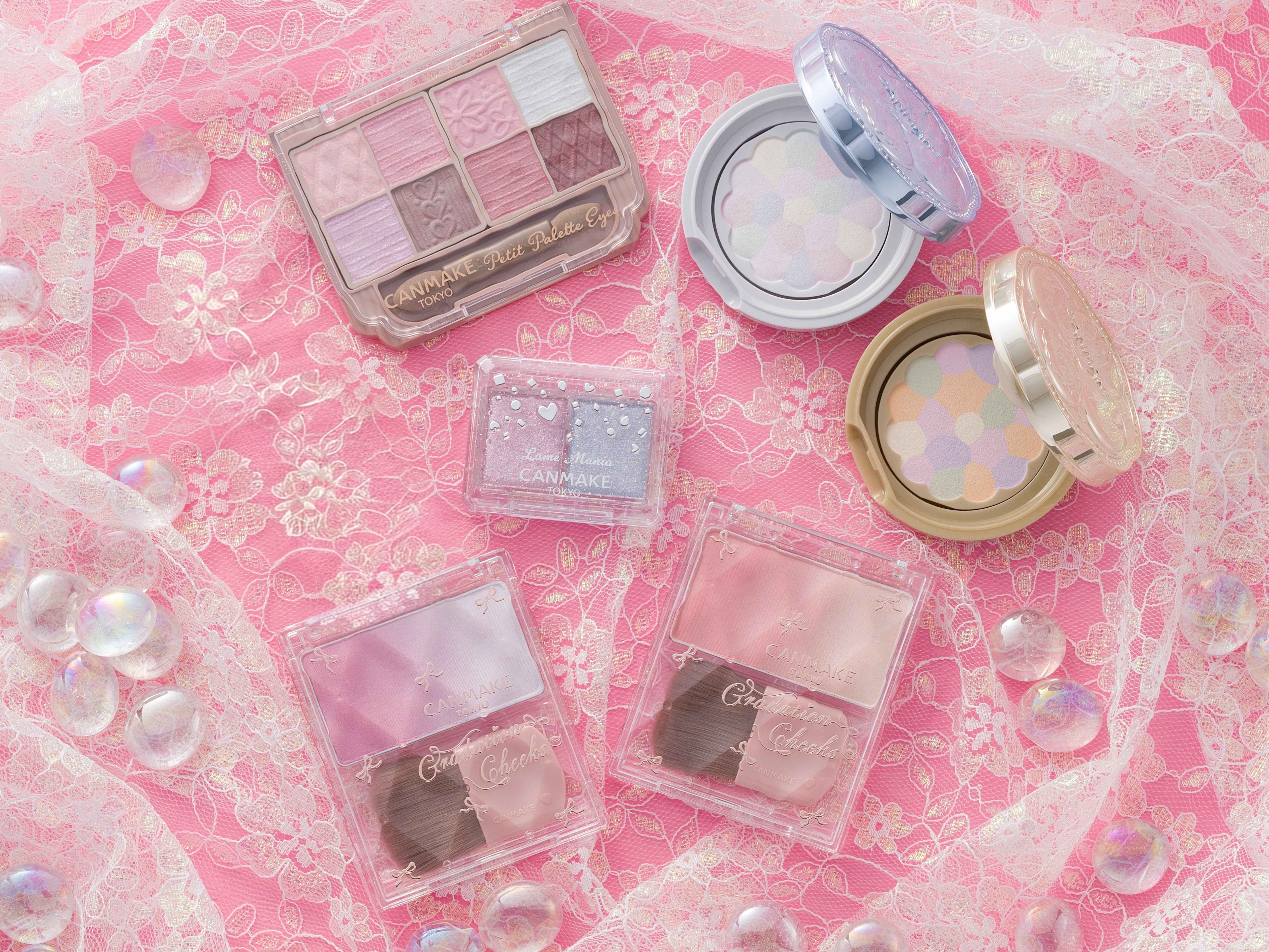 レースの上に化粧品のパレットとブラシセットが配置されています。