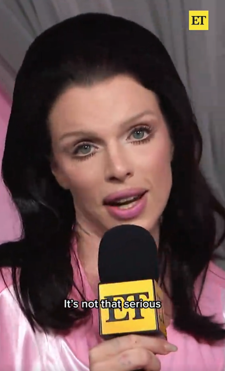 Person speaking into a microphone during an interview, caption reads "It's not that serious."