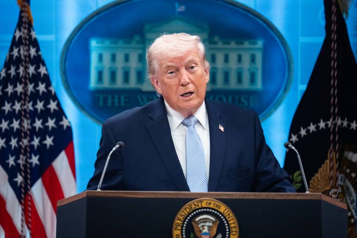 A idiosyncratic   successful  a suit   speaks astatine  a podium with the U.S. statesmanlike  seal, successful  beforehand   of a backdrop featuring the White House
