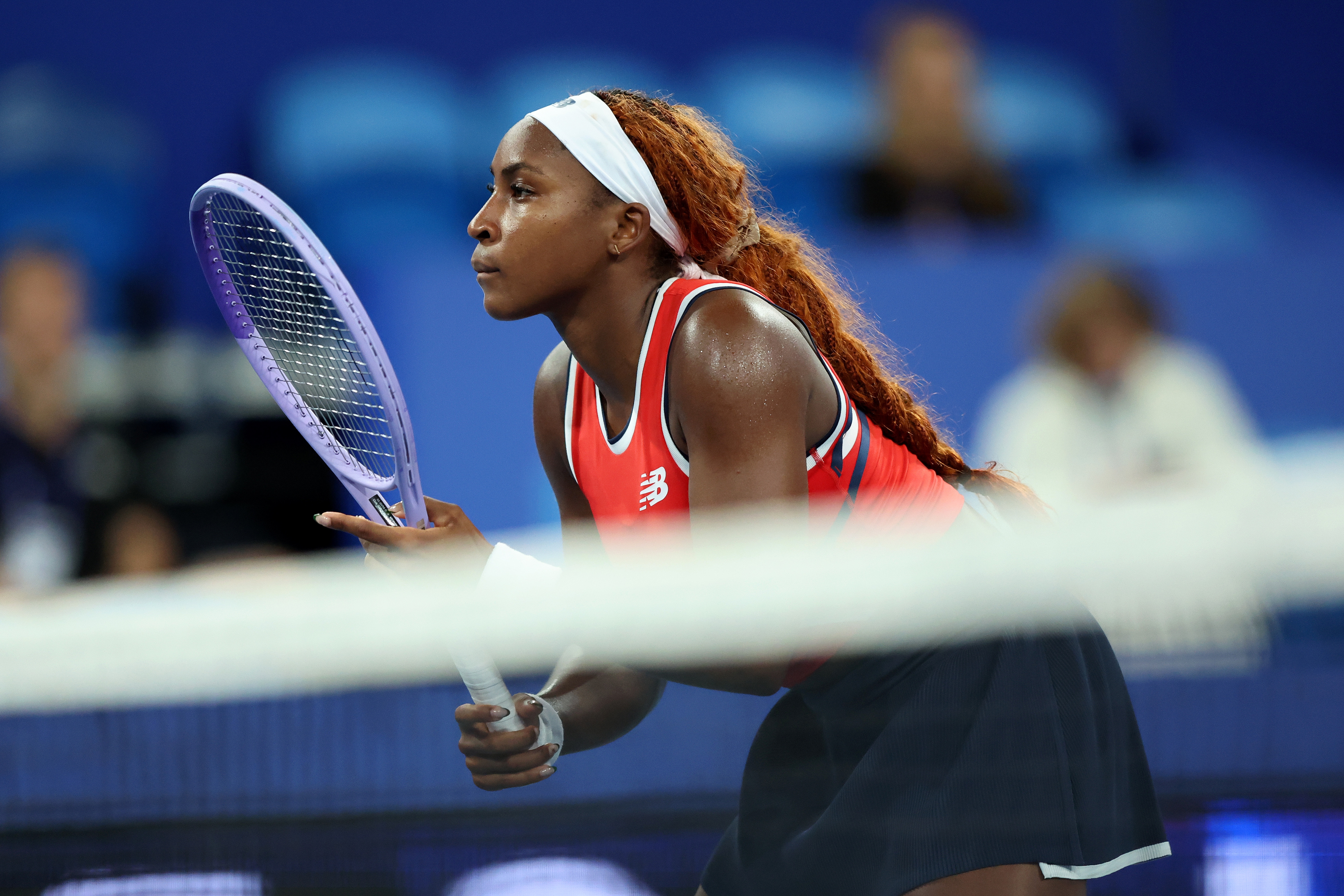 Coco Gauff focusing intently during a match, poised with racket successful  hand, wearing a sleeveless diversion  outfit
