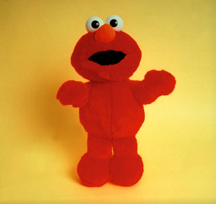 Elmo plush artifact  lasting  upright connected  a plain background