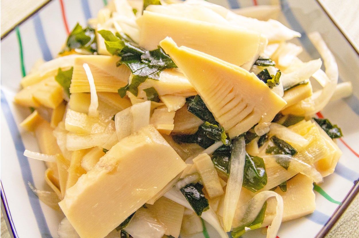 タケノコと野菜の炒め物が、ストライプ模様の器に盛られている料理。