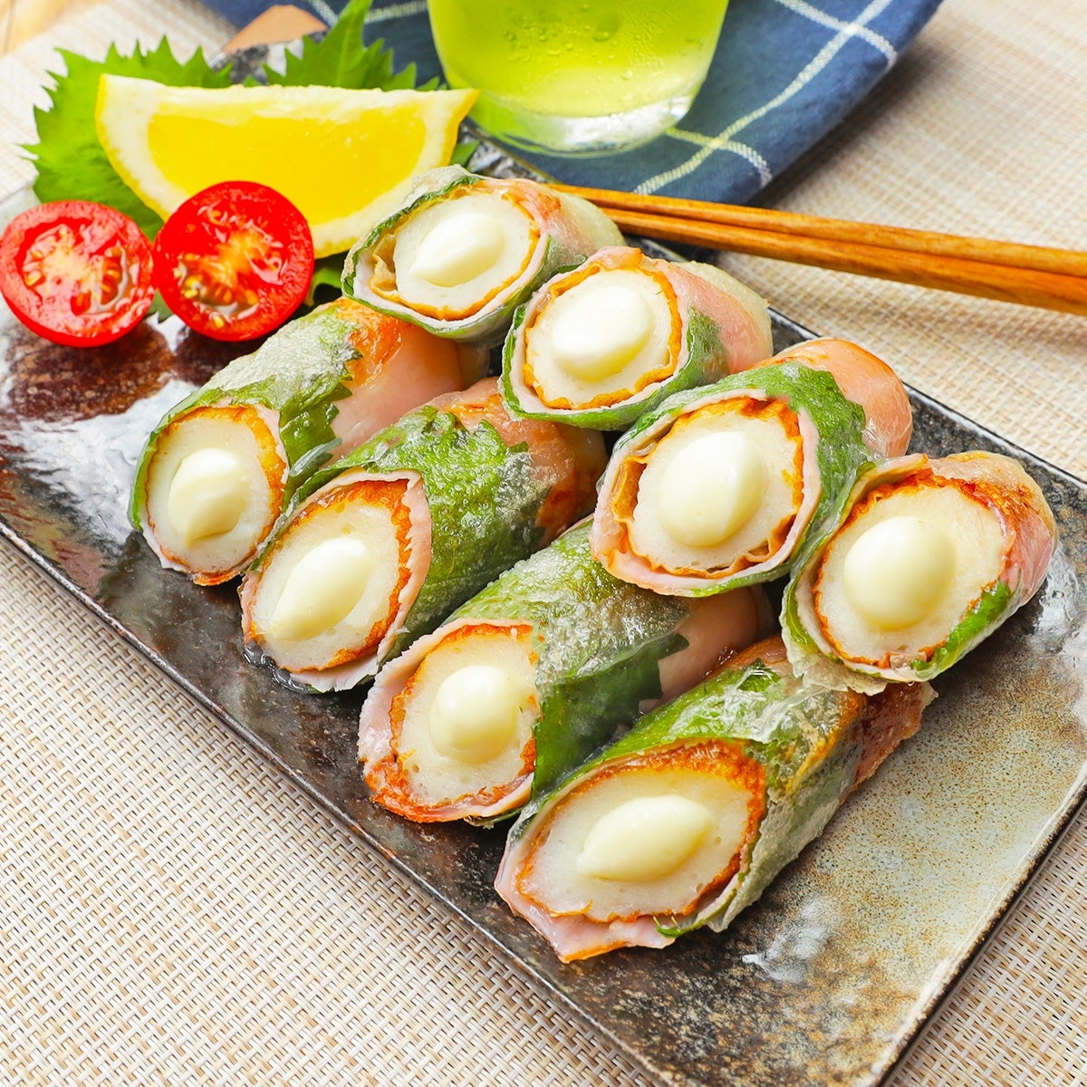 お皿に盛られたチーズ入りおつまみ生春巻き。添えられたミニトマトとレモンスライスも見える。