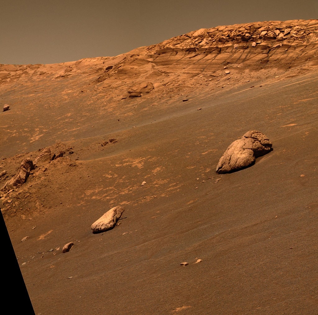 Marslandskap med steinete terreng og bølgende åser, fanget av en rover