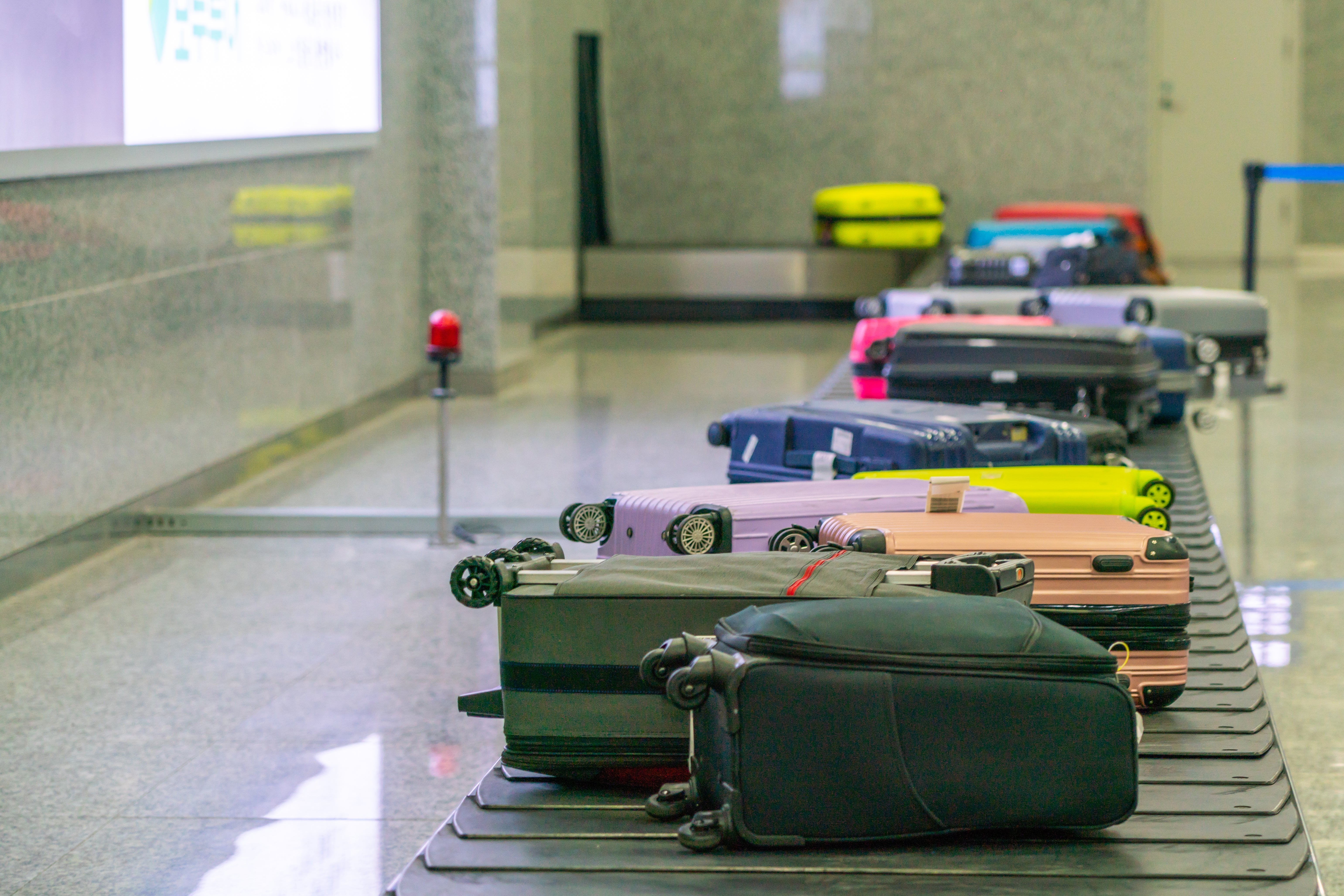 Luggage lined up   connected  an airdrome  baggage carousel, awaiting collection