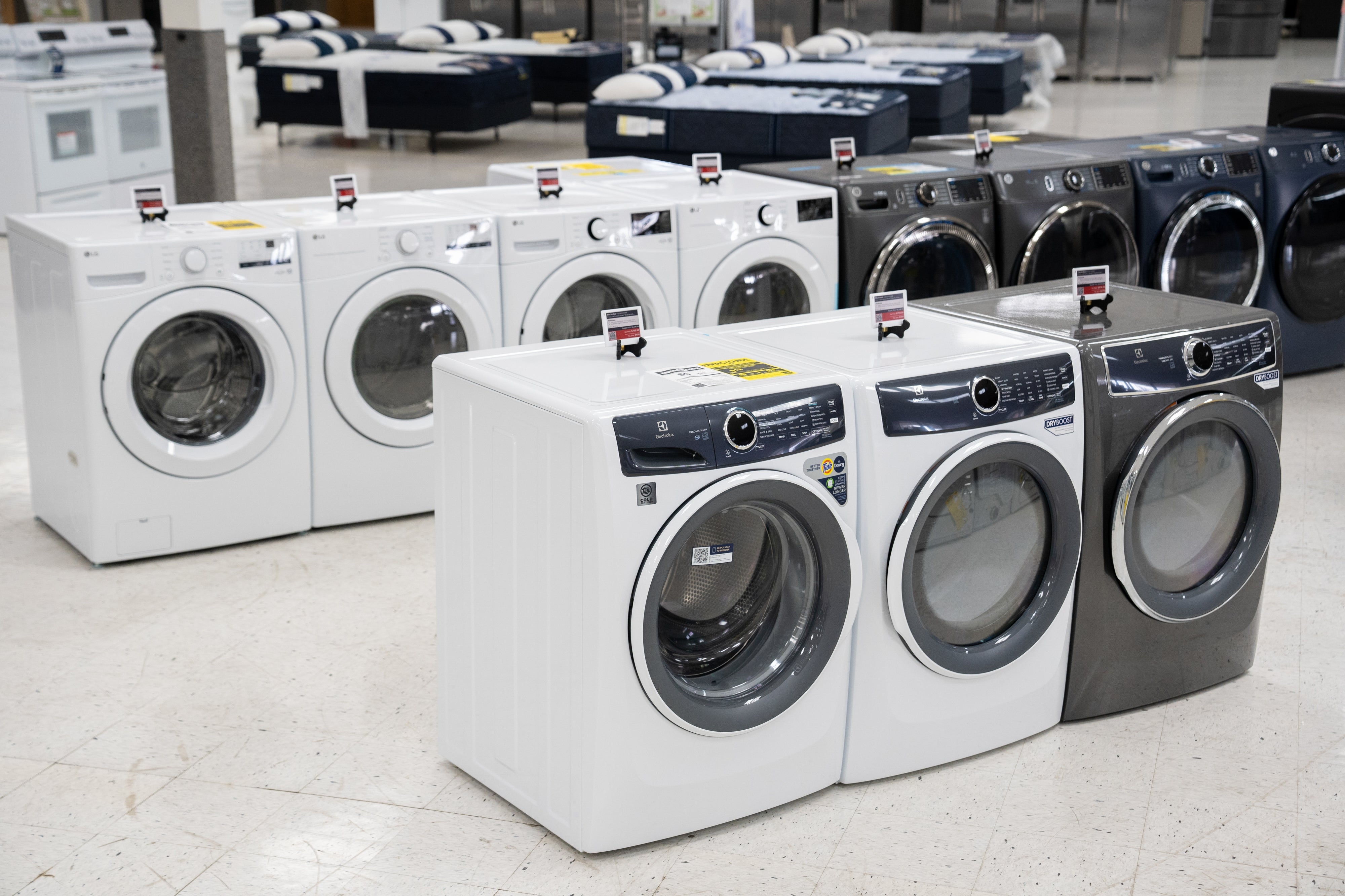 Washing machines displayed successful  a showroom, with assorted  models and brands lined up   successful  rows connected  a tiled floor