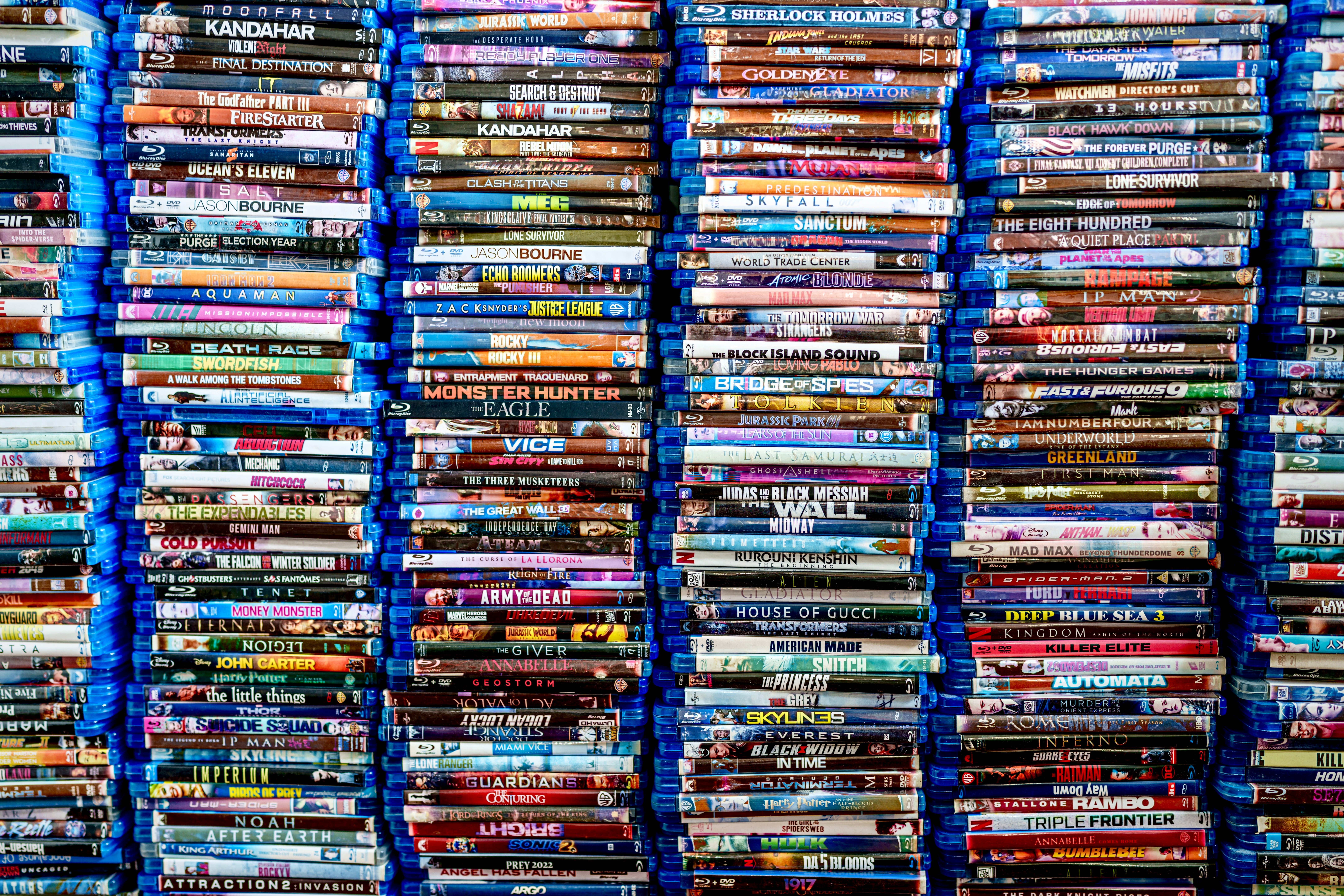 Stacks of Blu-ray movie   cases, tightly packed, showcasing a wide   assortment  of movie  titles