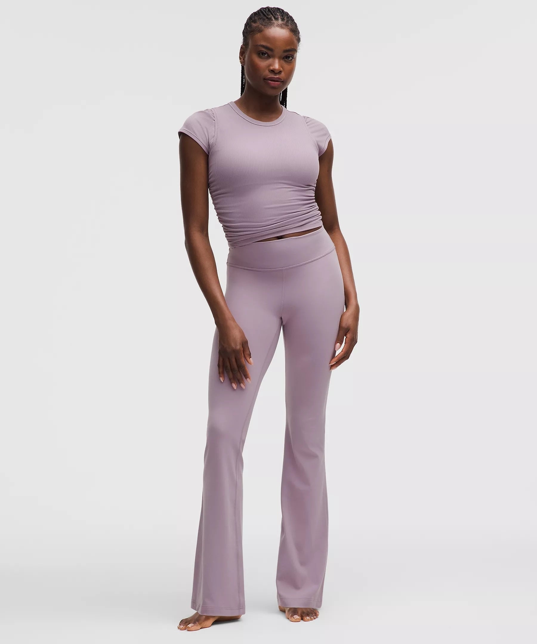 Person modeling a fitted short-sleeve top and flared leggings. Ideal for shopping or casual wear