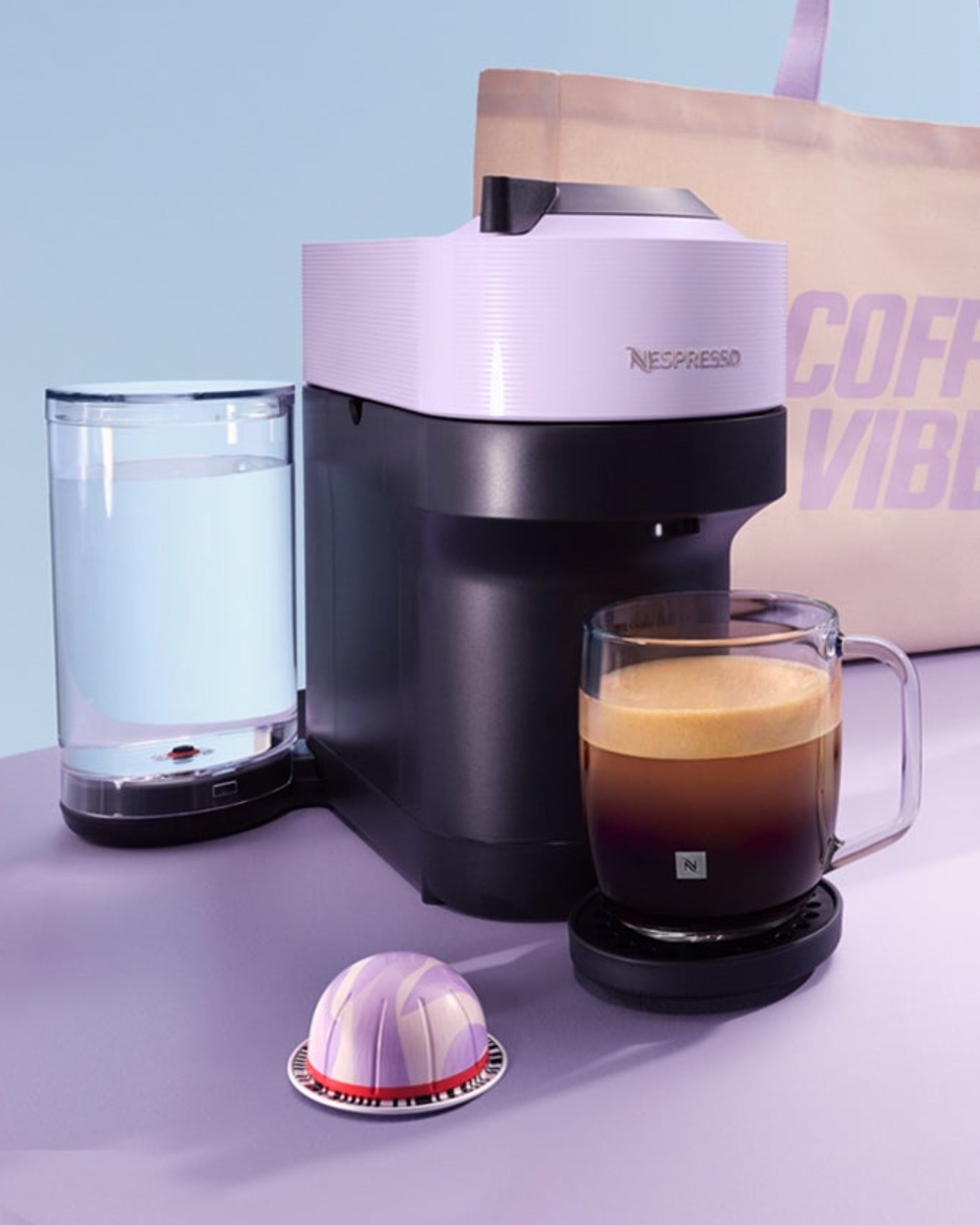 Coffee maker set with a brewing machine, mug, pods, travel tumbler, and a tote bag labeled "Coffee Vibes."