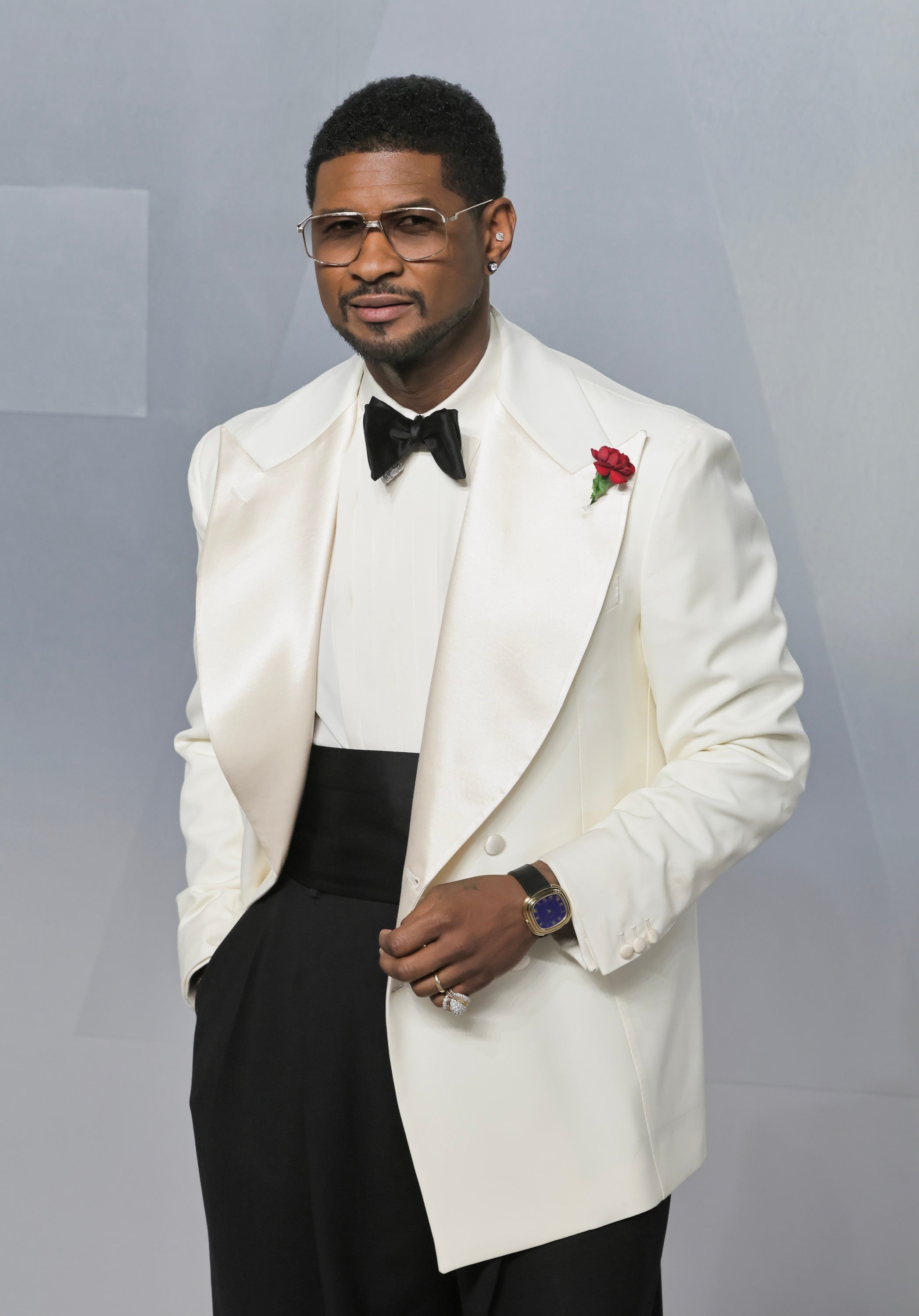 En person i stilig smoking med hvit jakke, svart sløyfe og roseboutonniere på et stilig arrangement