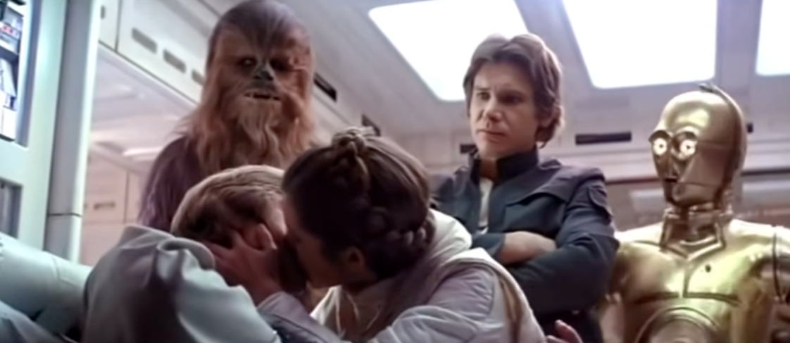 Characters from a sci-fi movie, including a Wookiee, a robot, and radical successful futuristic attire, ticker a mates kissing