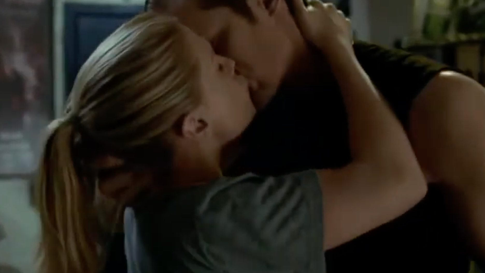 A mates passionately embraces indoors, sharing a kiss. Their postures suggest a adjacent and intimate moment