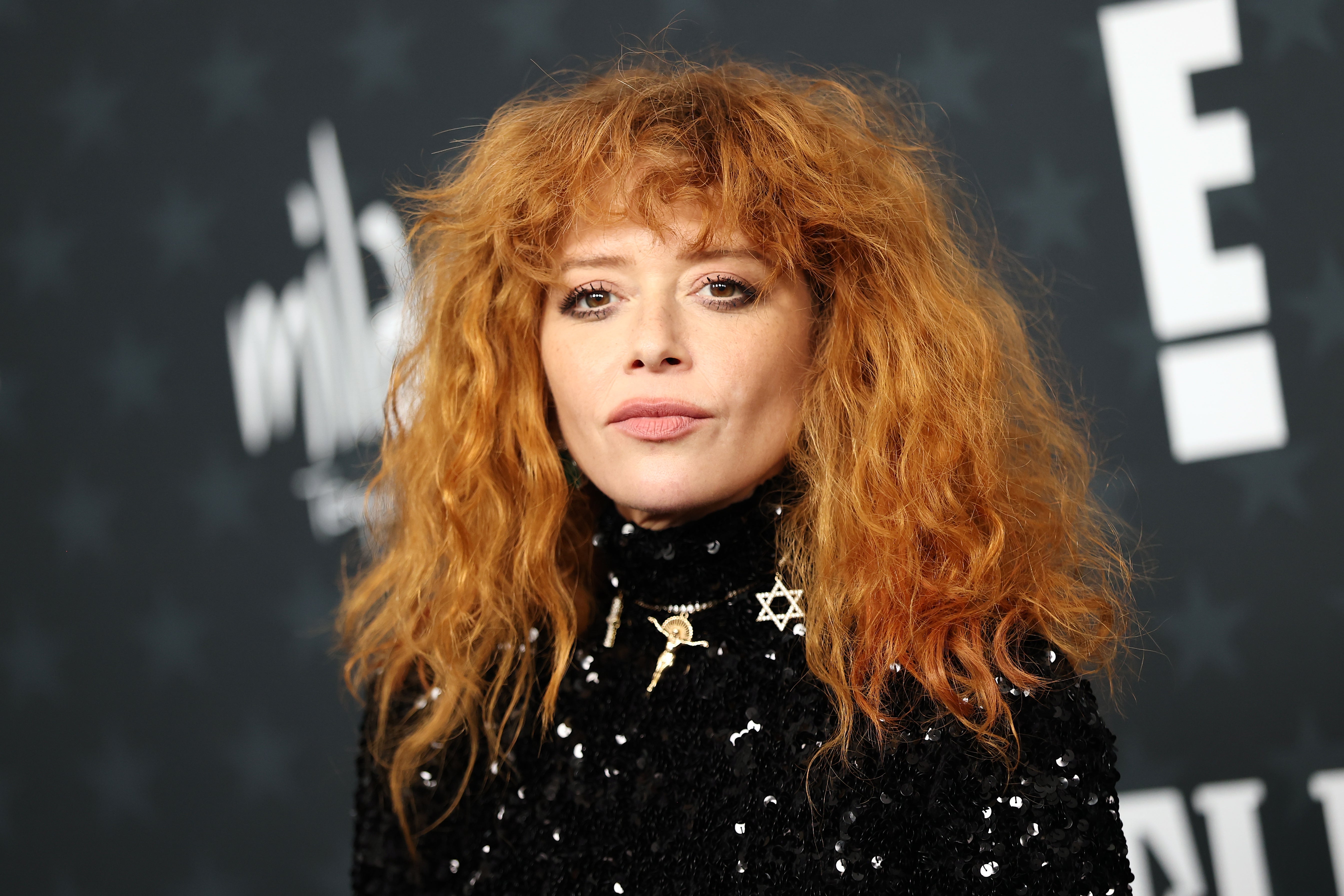 Natasha Lyonne med krøllete hår iført et antrekk med høy krage med paljetter på et kjendisarrangement