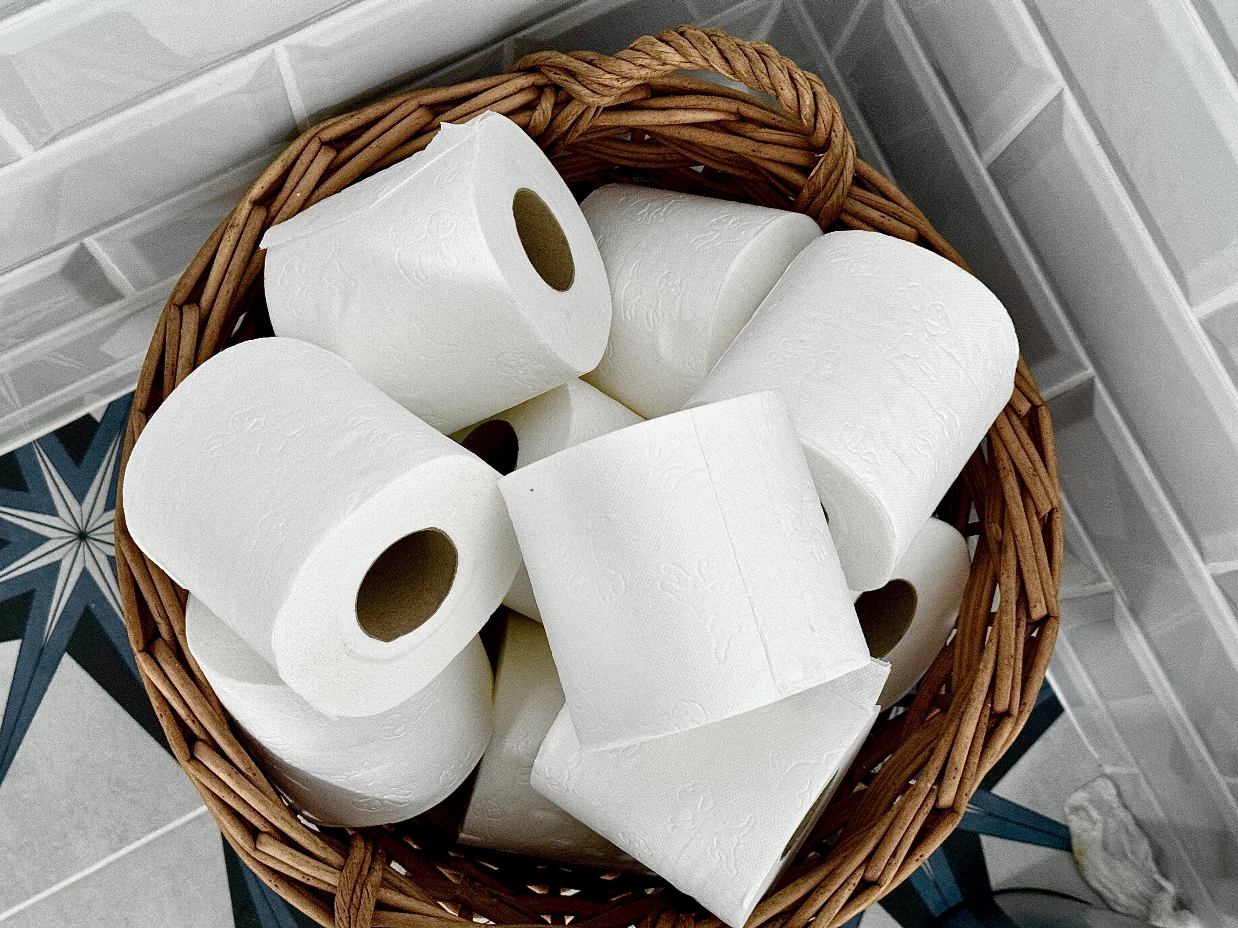 Keranjang dengan beberapa gulungan tisu toilet tersusun rapi