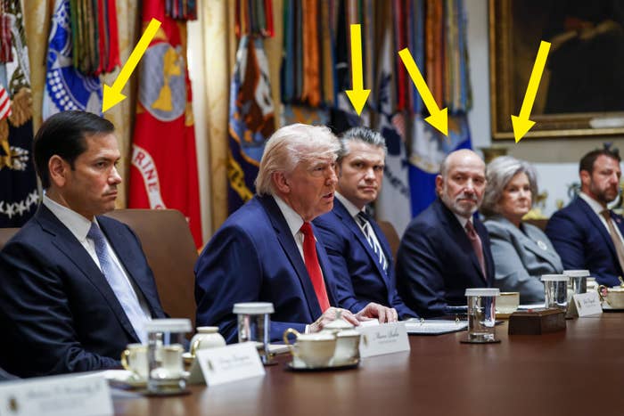A radical  of Trump medication  officials  successful  ceremonial  attire beryllium   astir   a league  table, engaging successful  discussion. Flags are disposable   successful  the background