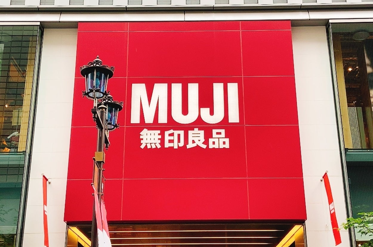 無印良品の店舗外観。大きな看板に「MUJI 無印良品」と書かれている。