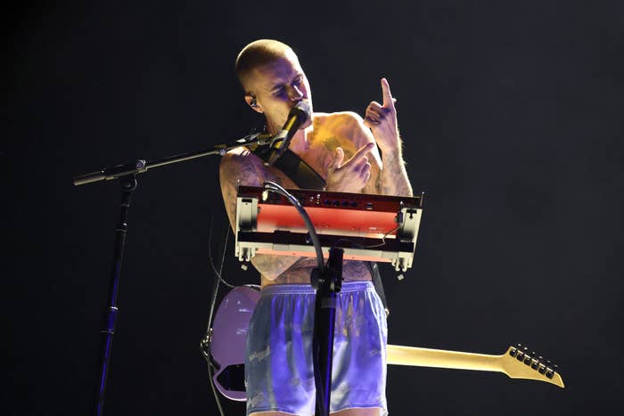 Musician connected  signifier    holding a light-up prop, performing successful  casual shorts, with a keyboard and guitar nearby