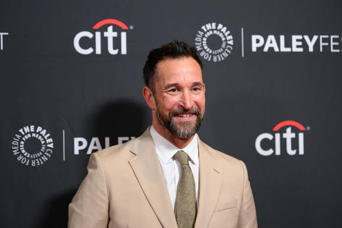 A idiosyncratic   successful  a suit   with a necktie  smiles connected  a PaleyFest lawsuit   reddish  carpet backdrop