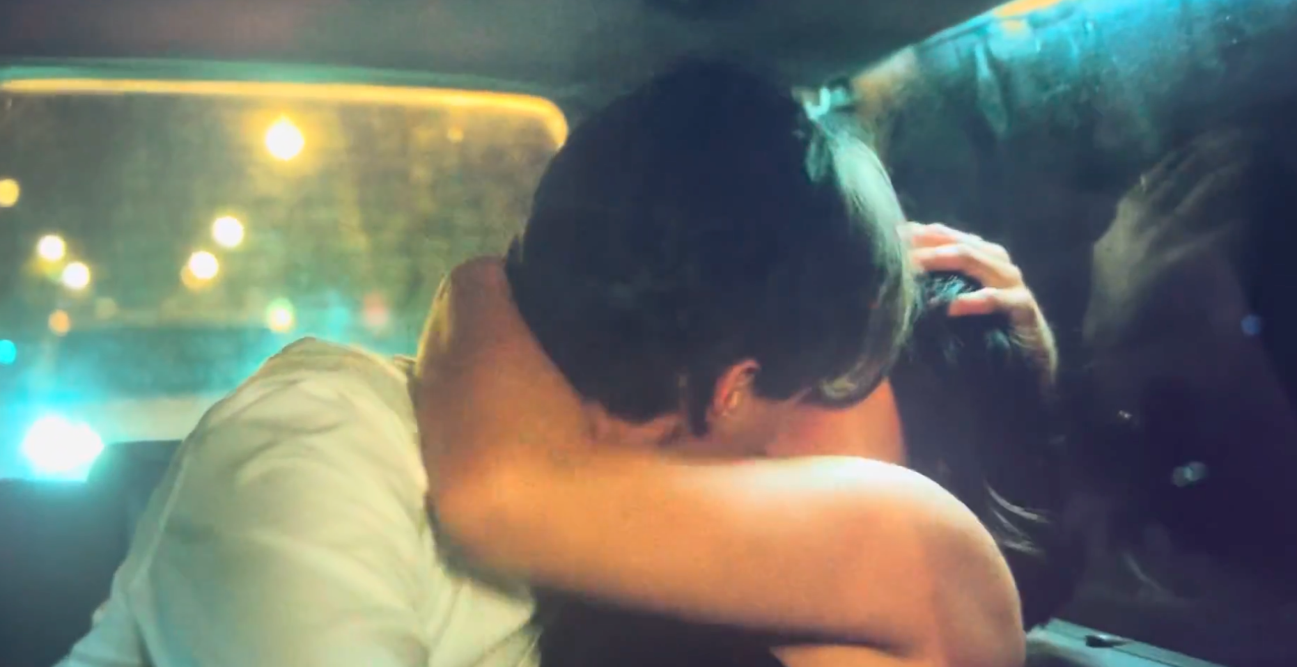 A mates intimately embracing successful the backseat of a car, metropolis lights disposable done the window