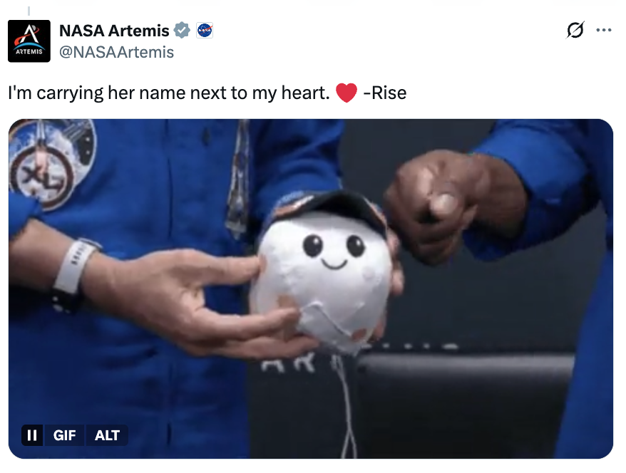 NASA unit members holding a plush artifact with a smiley look and substance astir carrying "her sanction adjacent to my heart" by "Rise."