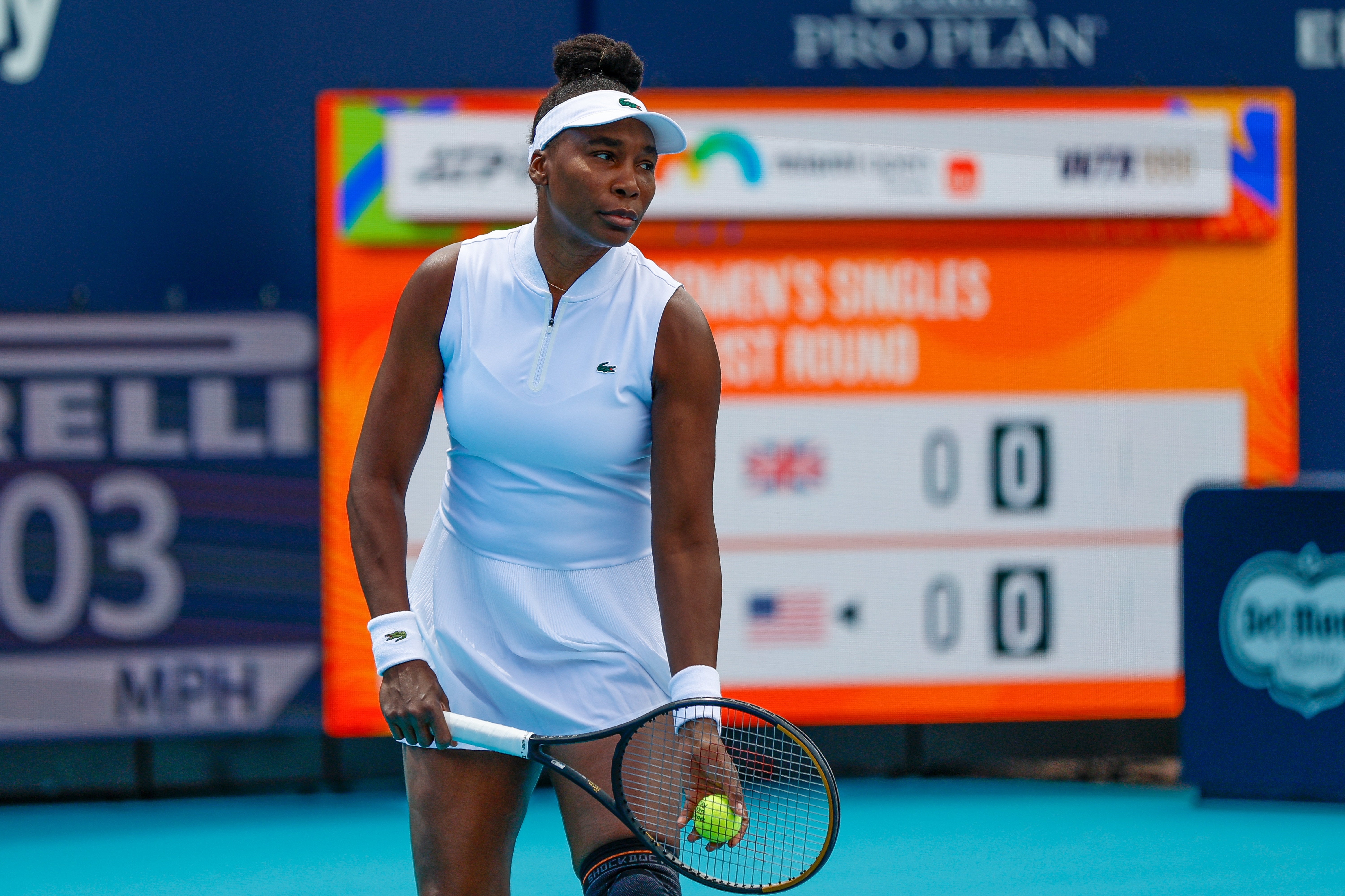 Tennis subordinate    successful  a sleeveless sports outfit holds a racket, poised connected  a court, with a scoreboard successful  the background