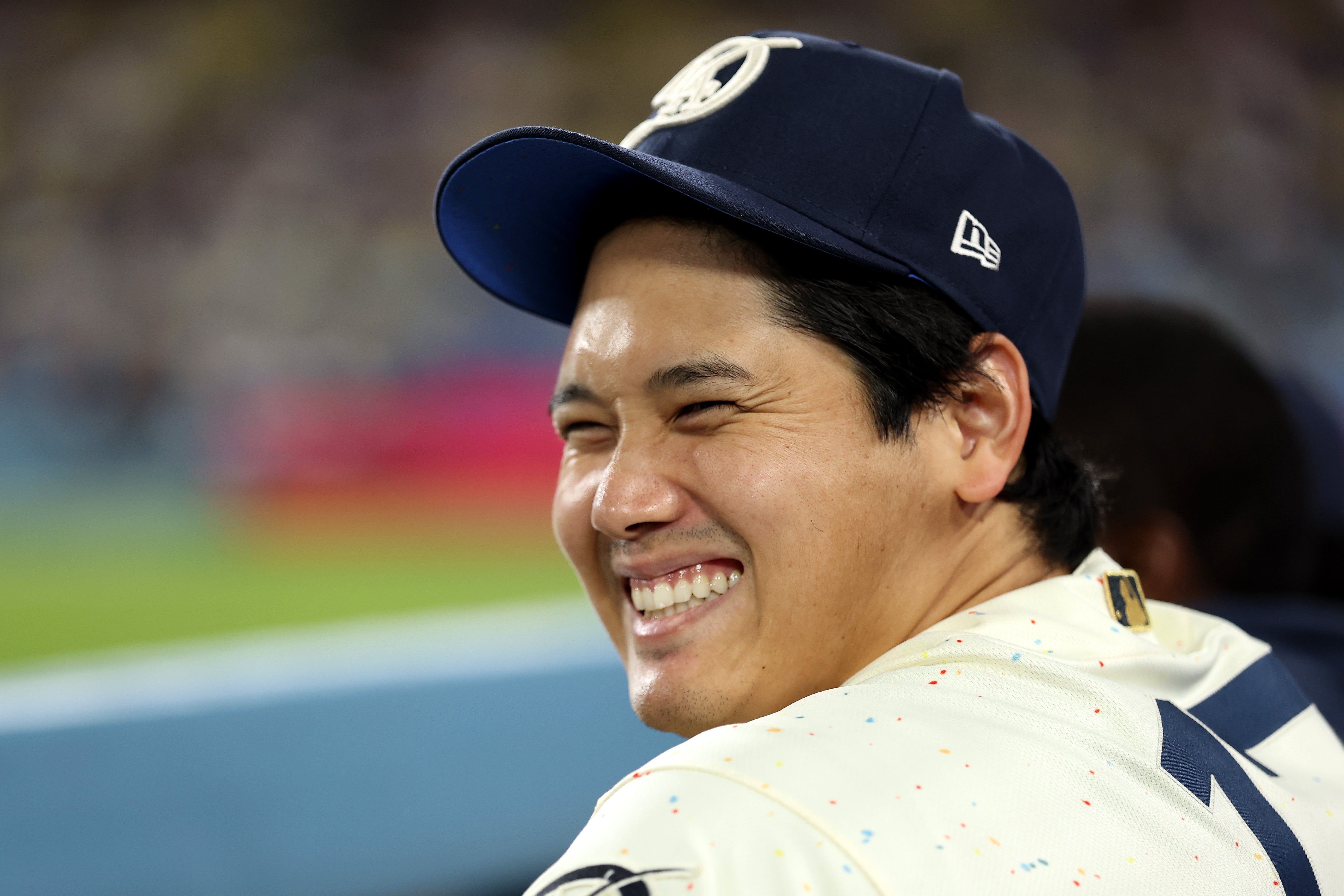 Person smiling, wearing a shot   headdress  and jersey, sitting successful  a stadium