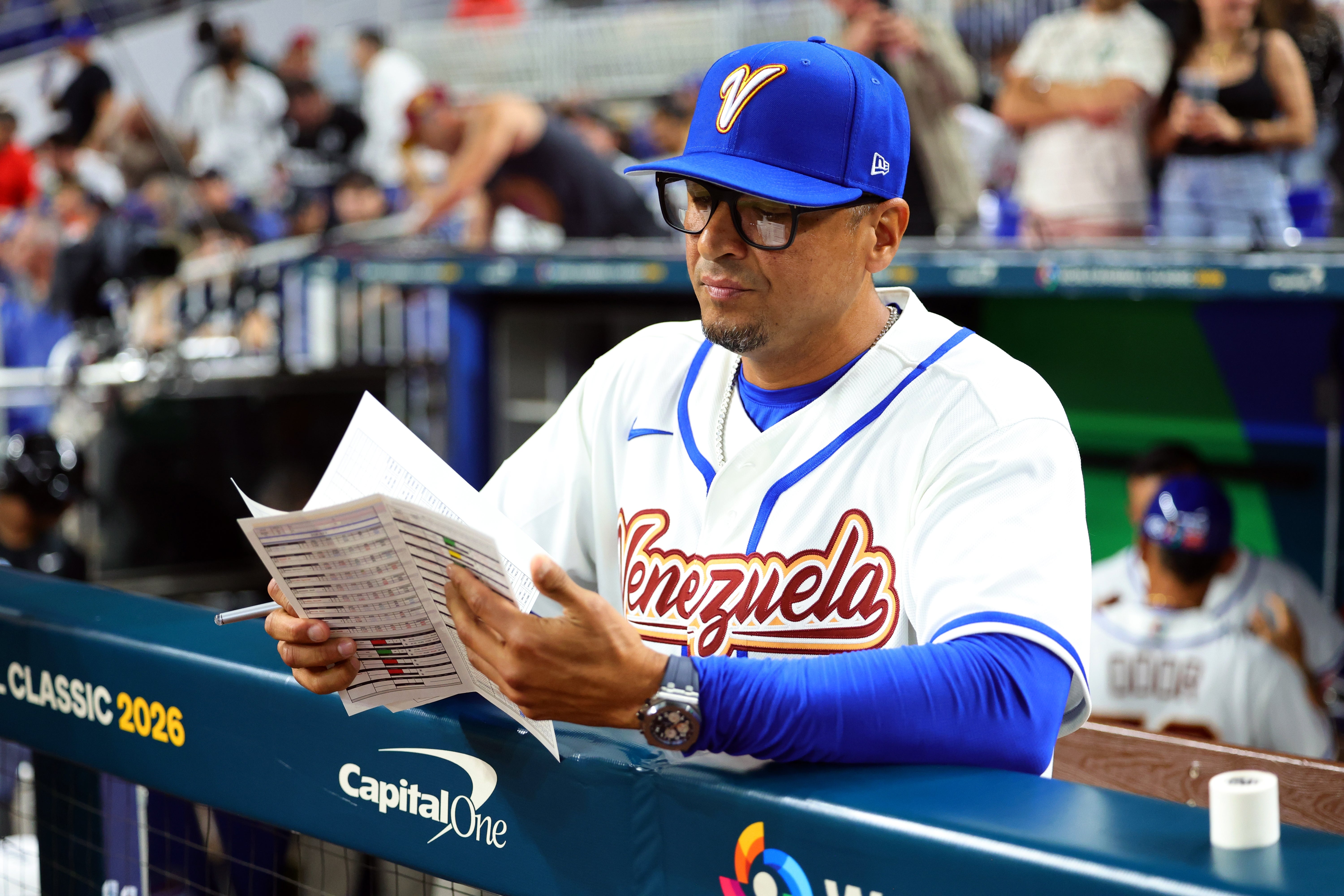 Person successful  a shot   dugout wearing a shot   azygous   and cap, reviewing papers