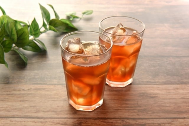 アイスティーが2杯テーブルに置かれている。葉の飾りが背景にある。