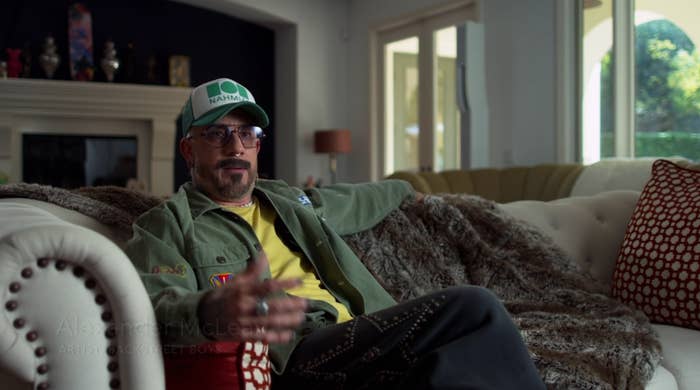 Person wearing a headdress  and casual overgarment   sits connected  a sofa successful  a surviving  room, gesturing portion    speaking