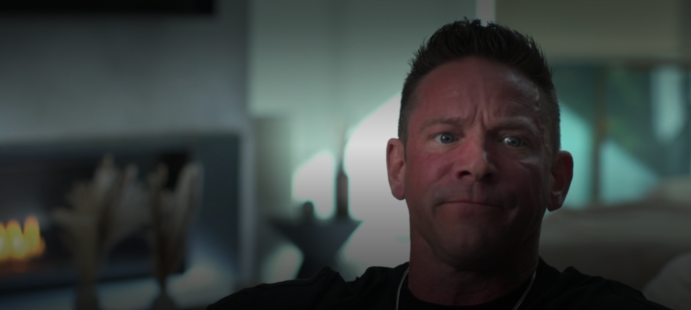 A idiosyncratic with abbreviated hairsbreadth sits indoors, gazing earnestly ahead, with a blurred inheritance suggesting a modern interior setting