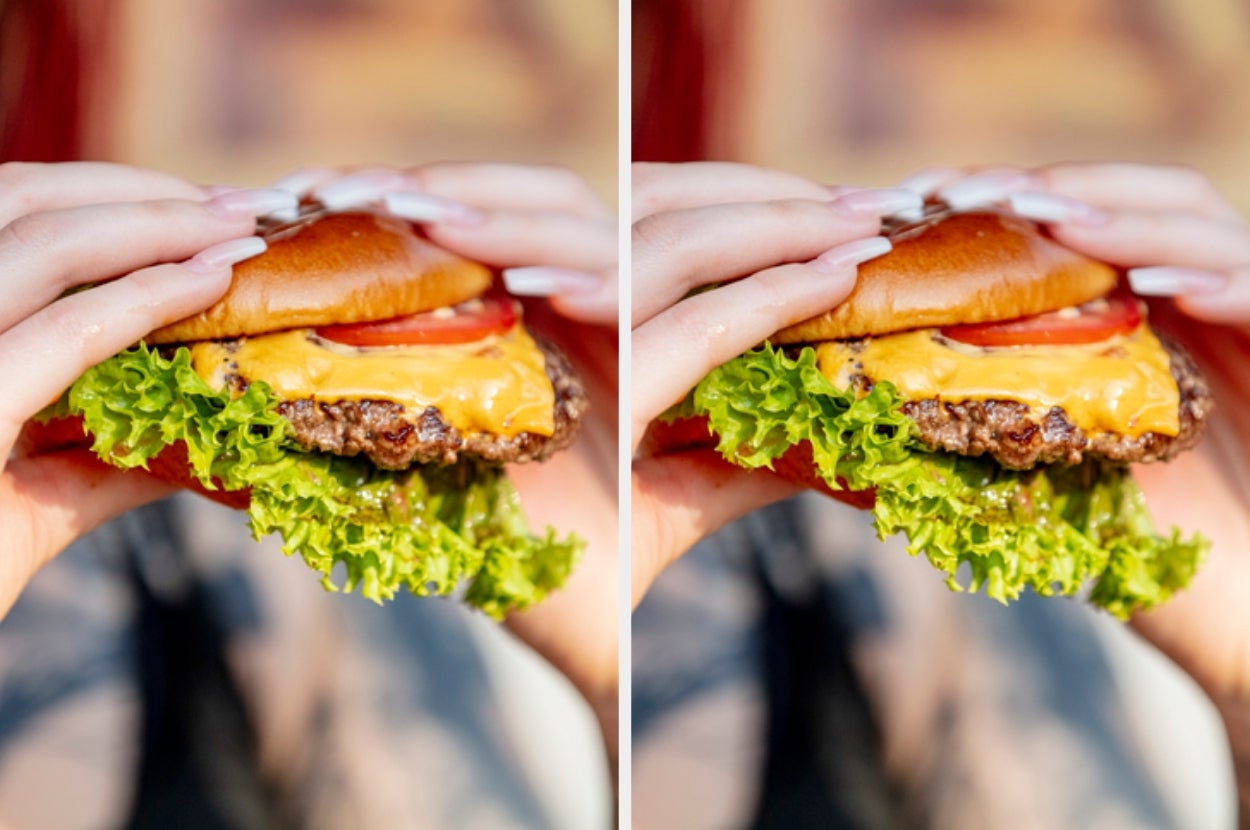 Person holding a cheeseburger with lettuce and tomato in both hands