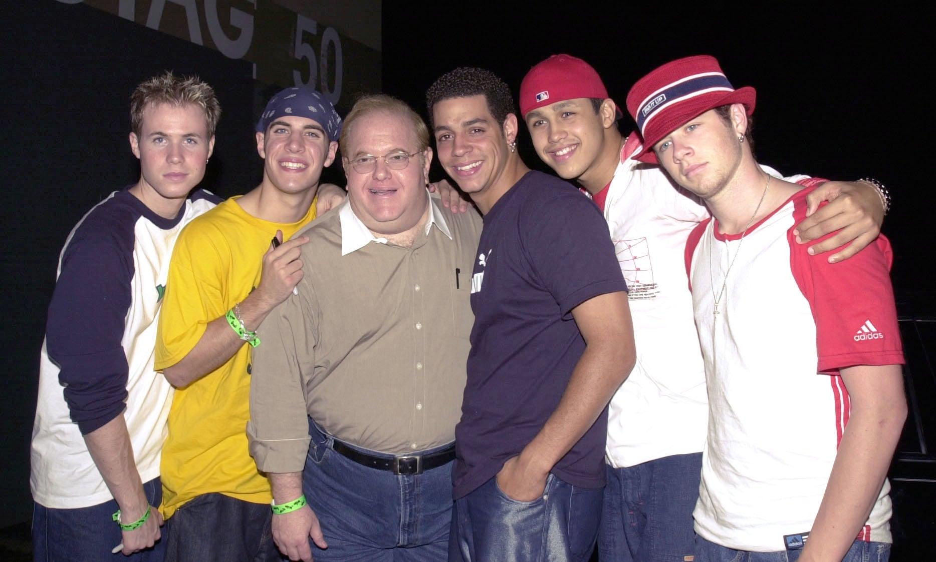 Group of young men casually dressed, posing with an older antheral successful a beige shirt. They are smiling and lasting adjacent together