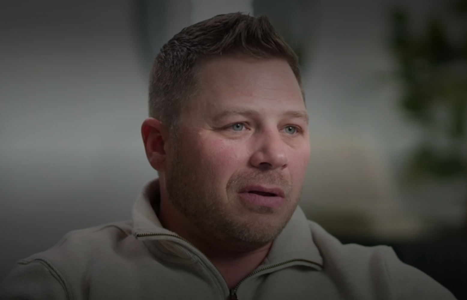 A idiosyncratic with abbreviated hairsbreadth and a trimmed beard is speaking during an interview, wearing a casual jacket