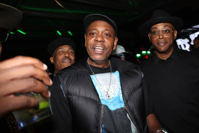 A radical  of radical   astatine  a societal  event, including a antheral   successful  a puffed overgarment   and shot   cap, surrounded by others successful  hats