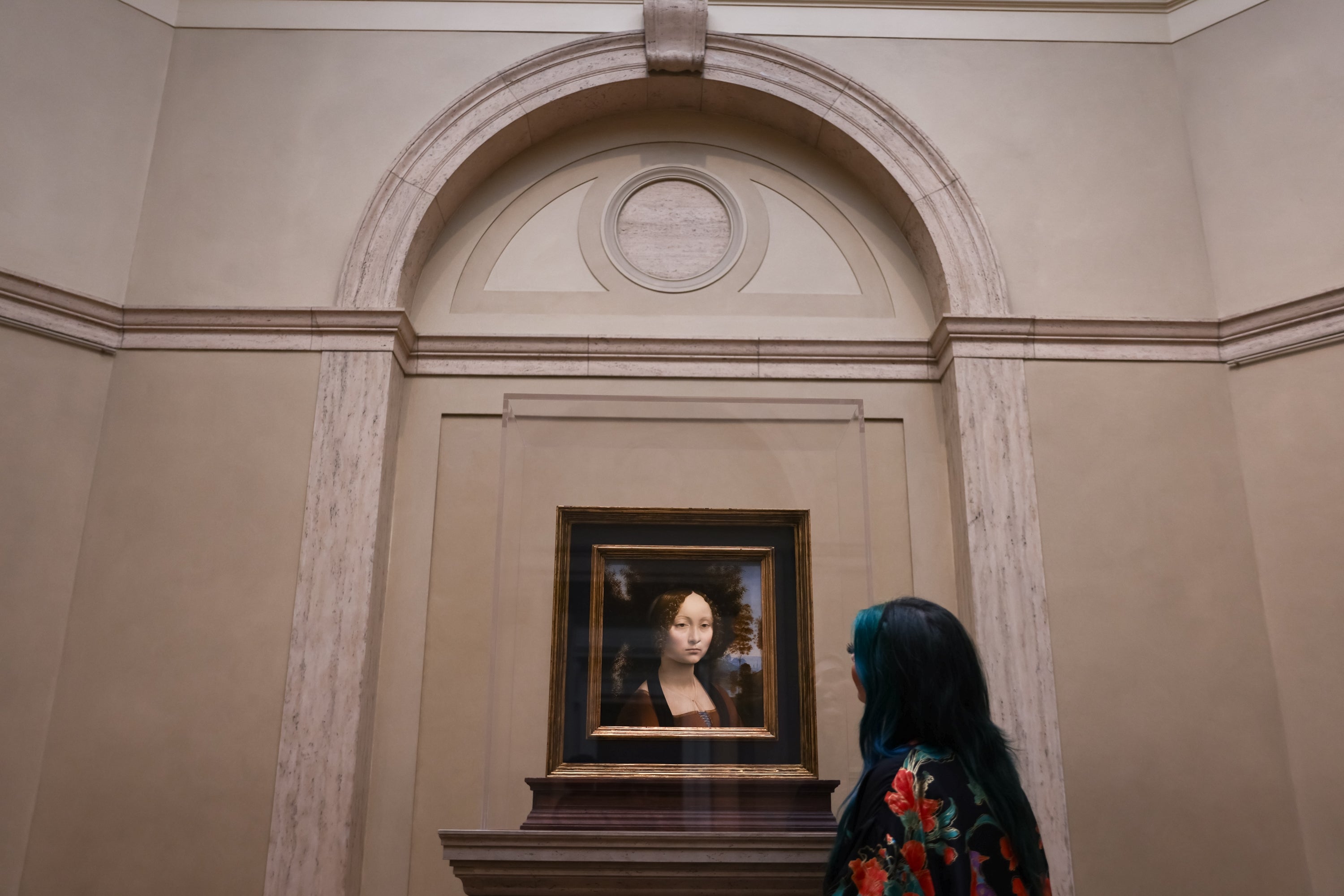 Person viewing a framed representation    successful  a gallery, surrounded by ornate architecture