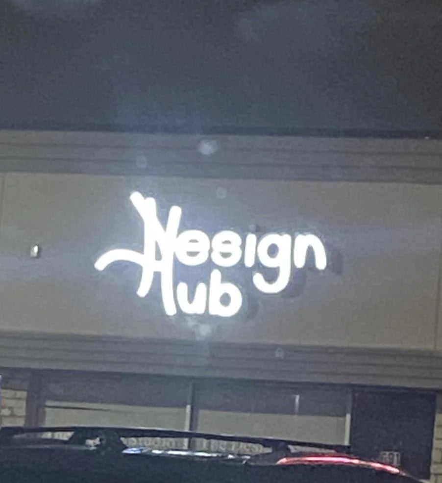 Illuminated motion   that reads "Design Hub" connected  a building's exterior, seen astatine  night