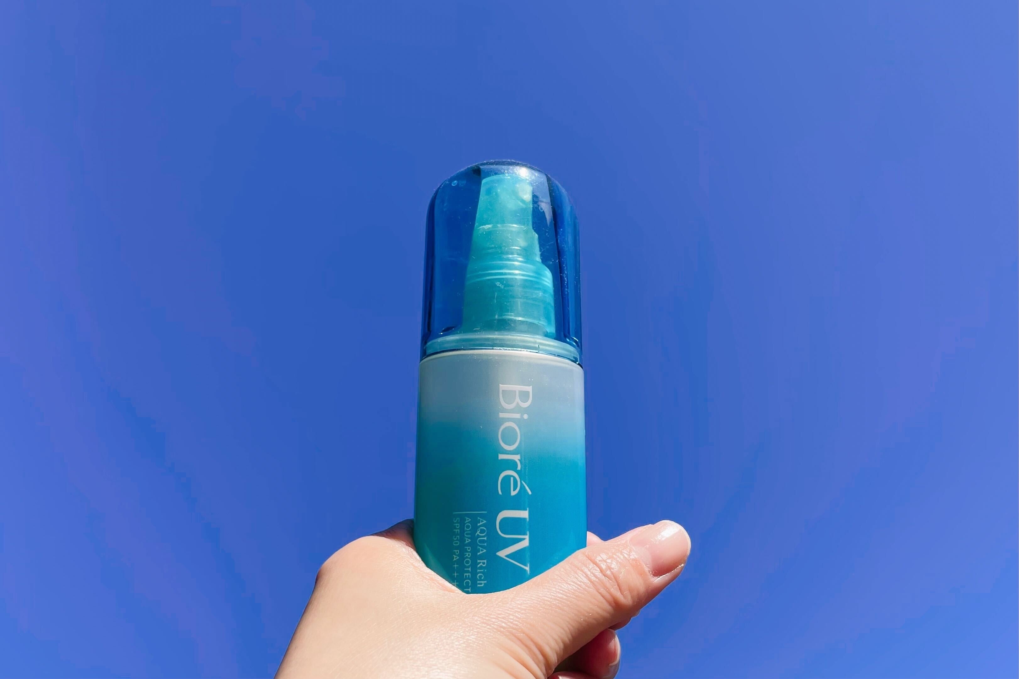 青空の下でBiore UVスプレーを持つ手。