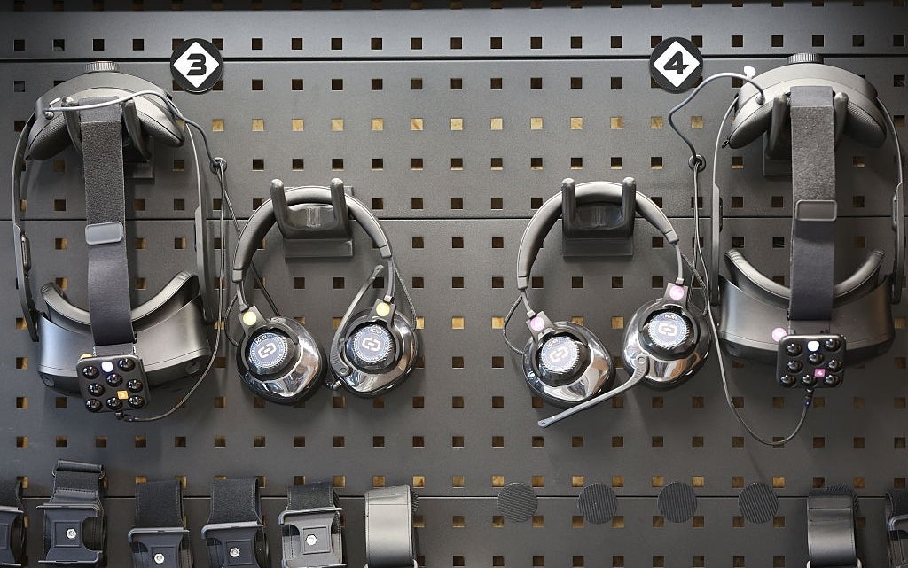 Virtual world  headsets and controllers displayed connected  a pegboard with labeled sections