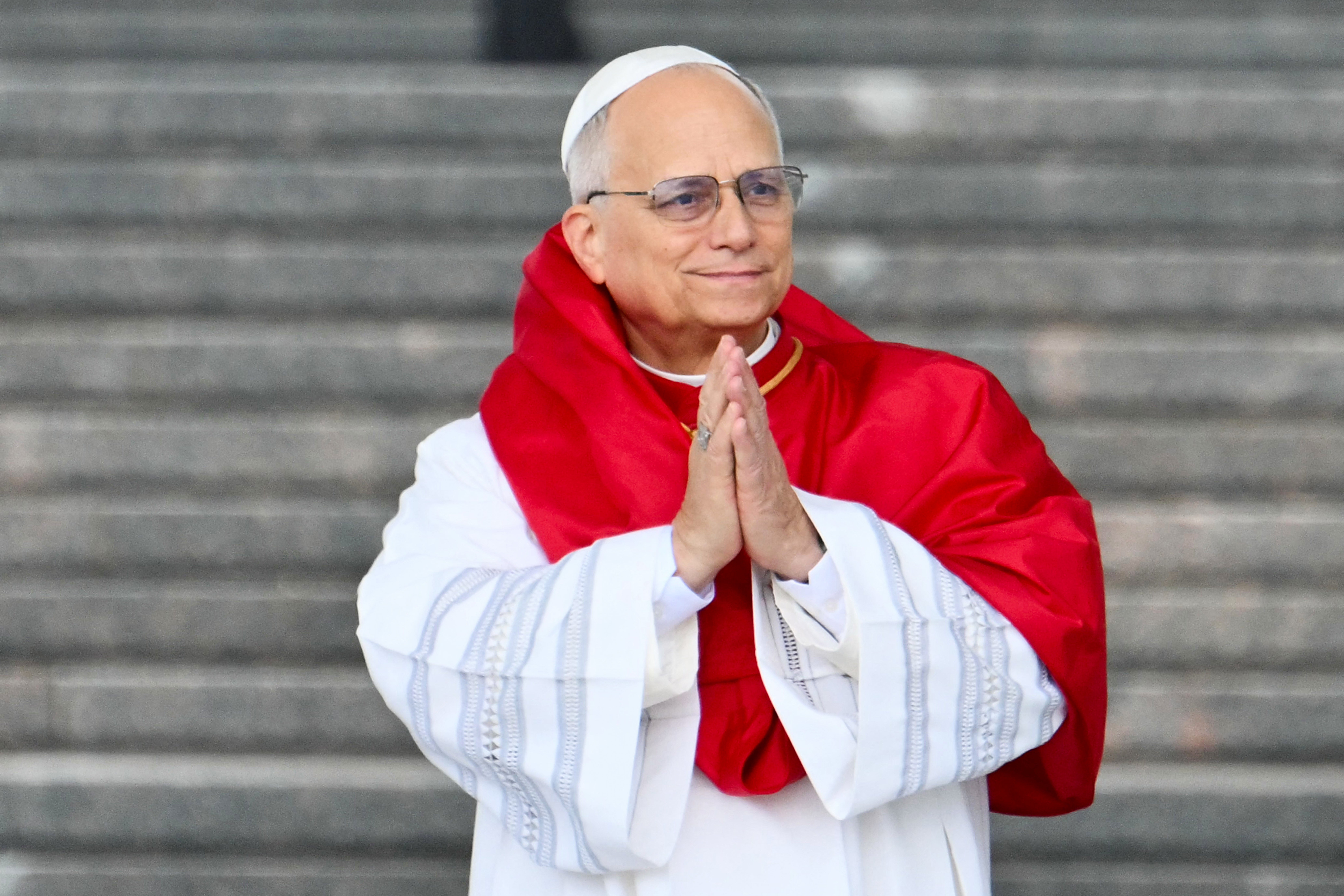 A idiosyncratic   successful  spiritual  attire, wearing a robe with reddish  draped fabric, stands with hands clasped together, successful  beforehand   of steps