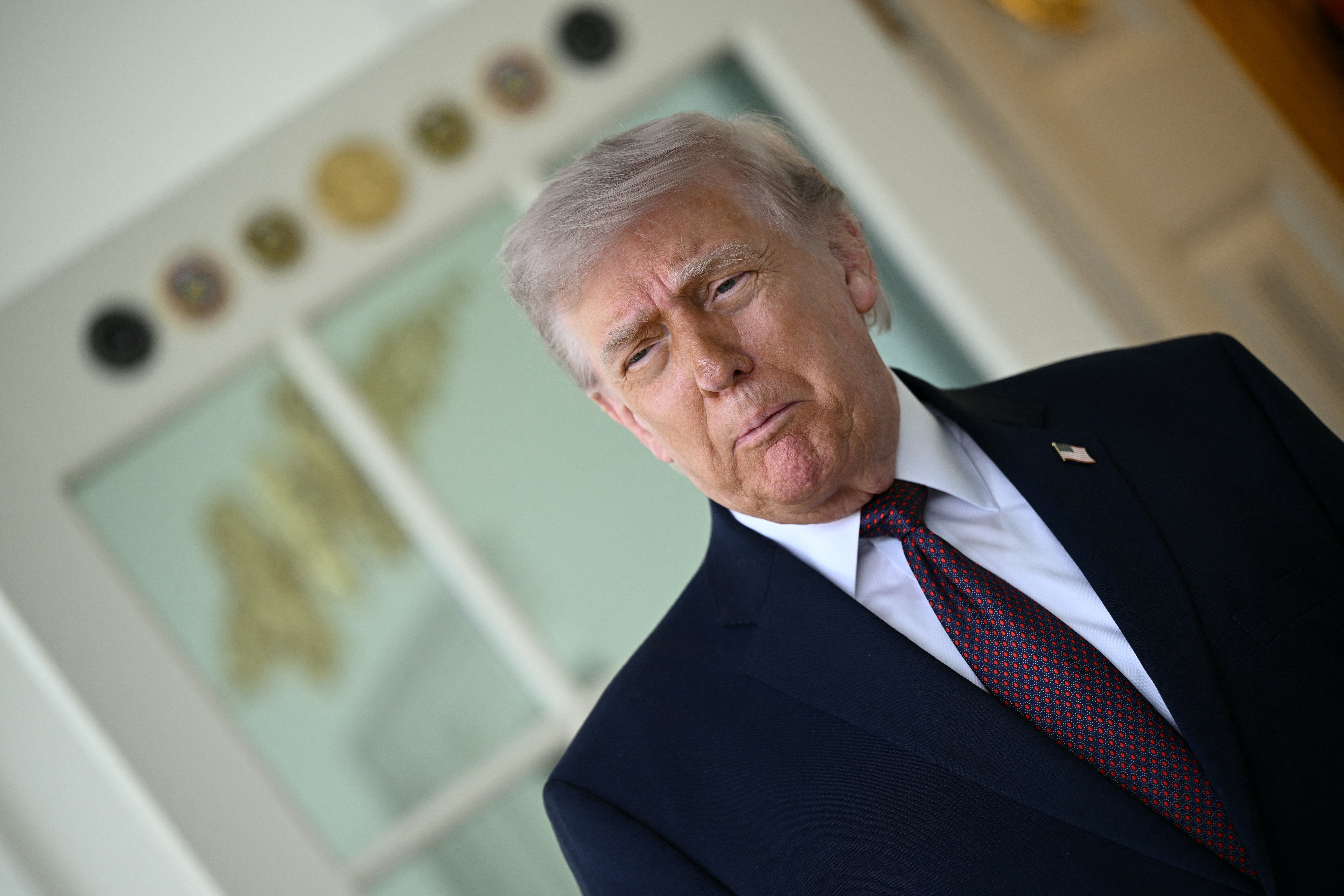 I can't place  the idiosyncratic   successful  this image. The idiosyncratic   is wearing a suit   with a tie, lasting  indoors with an look  of contemplation