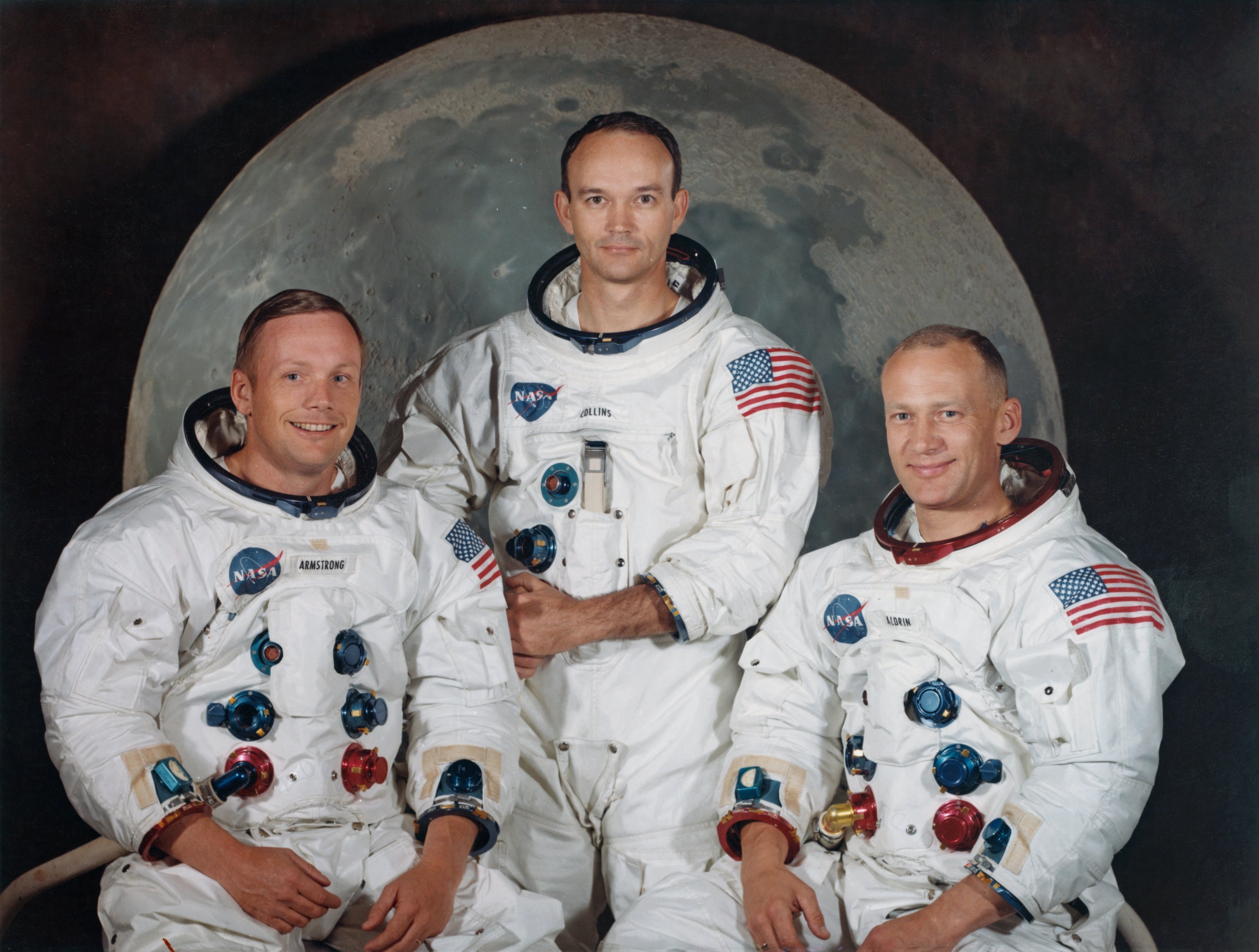 Three astronauts successful  NASA spacesuits airs  successful  beforehand   of a satellite  backdrop, representing the Apollo 11 mission