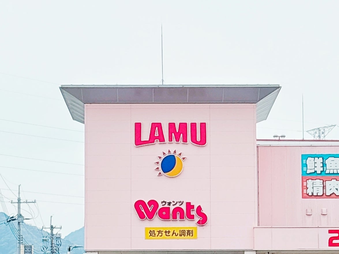 建物の上に「LAMU」と「Wants」の看板が掲げられています。