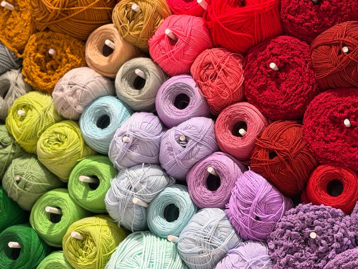 Colorful yarn rolls stacked successful  rows, showcasing assorted  textures and thicknesses for crafting oregon  knitting projects
