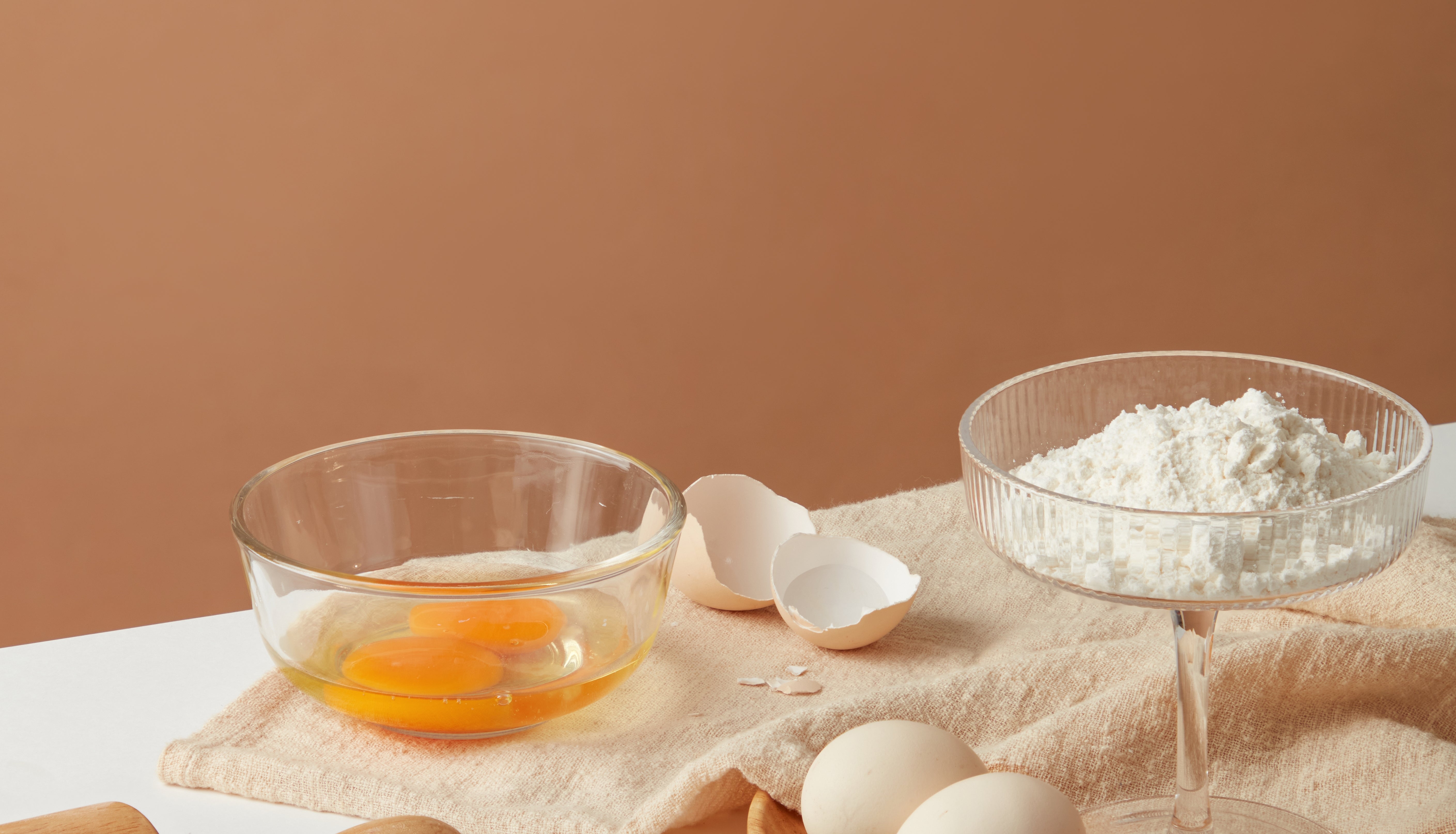 Baking setup with eggs, flour successful  a solid  dish, a rolling pin, and wheat grains connected  a tabletop
