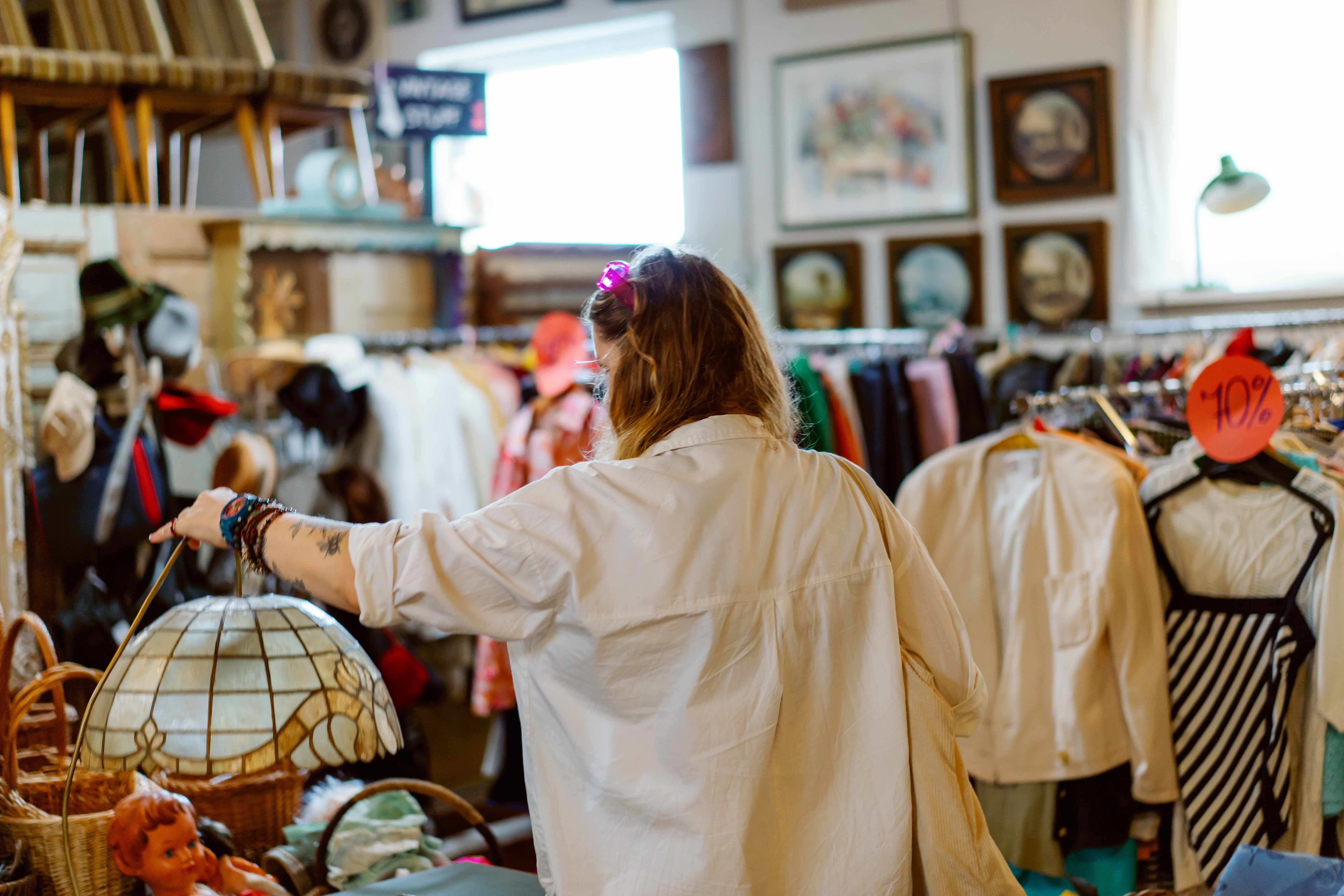Person browsing a vintage store, looking astatine  covering  and different   items