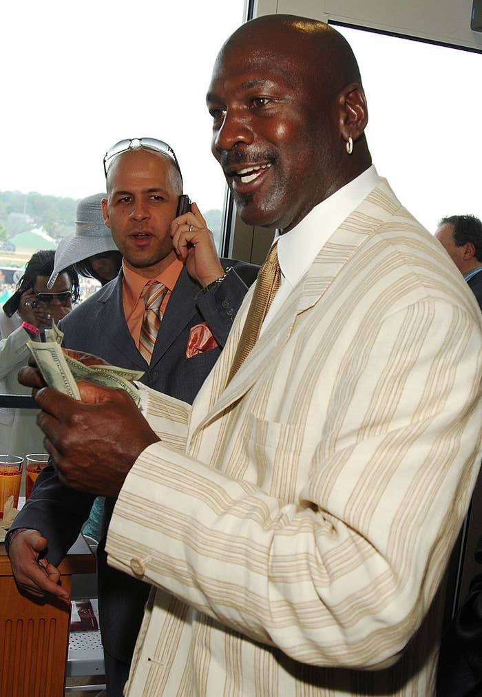 A antheral   successful  a striped suit   smiles portion    holding money. Another idiosyncratic   successful  a suit   and chapeau  is successful  the background, utilizing a phone