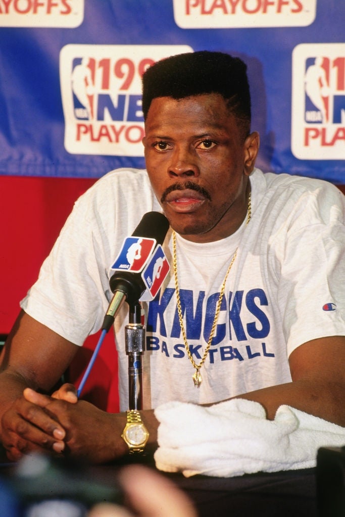 A hoops  subordinate    successful  a "Knicks Basketball" garment  speaks astatine  a property   league  with an NBA logo backdrop during the 1993 playoffs